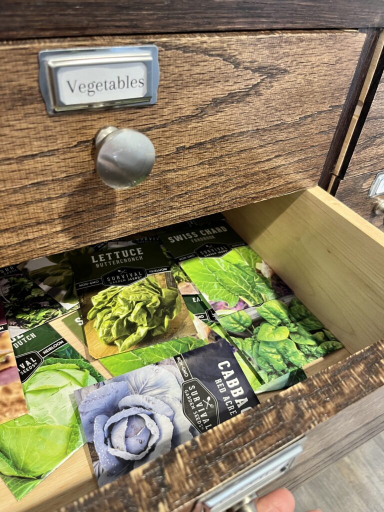 An open drawer with assorted seed packets inside.